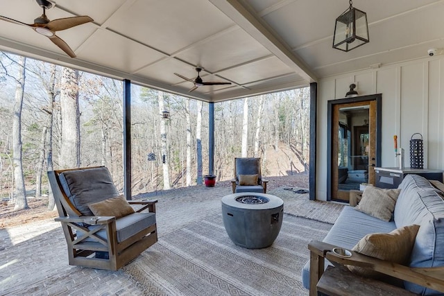 sunroom / solarium with ceiling fan, a wealth of natural light, and coffered ceiling