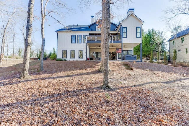 back of property with a hot tub and ceiling fan