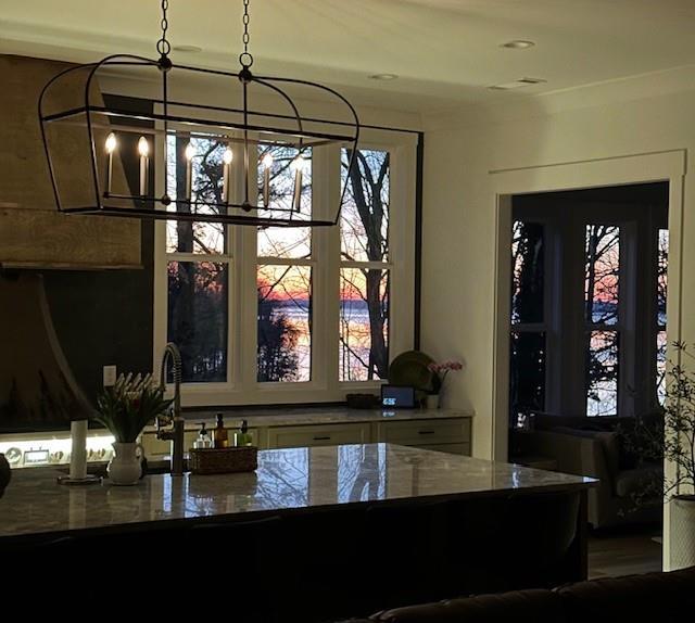 bar with hanging light fixtures and a chandelier