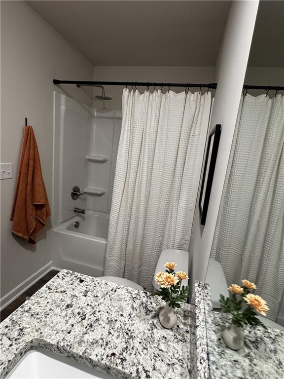 full bathroom with shower / bath combination with curtain, vanity, and toilet