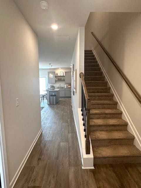 stairway with baseboards and wood finished floors