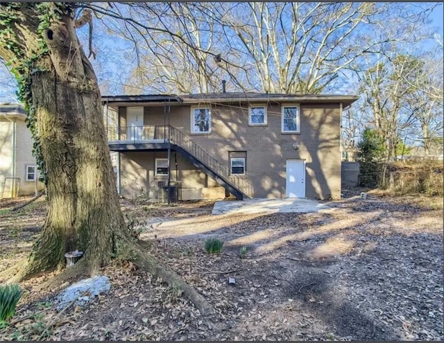 rear view of house featuring stairway and central AC