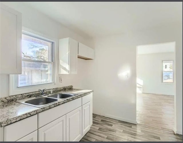 kitchen featuring a sink, white cabinets, and light wood finished floors