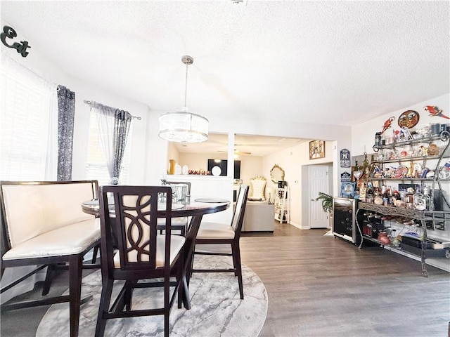 dining space with a textured ceiling and wood finished floors