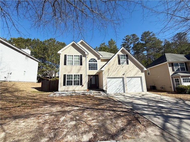 traditional-style house with a garage, concrete driveway, fence, and central air condition unit