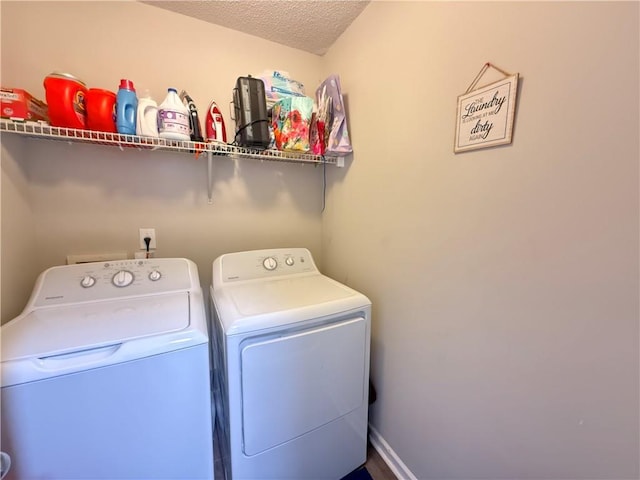 washroom featuring laundry area, a textured ceiling, and washing machine and clothes dryer