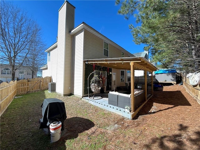 rear view of property featuring a fenced backyard, a patio, a chimney, and central AC unit