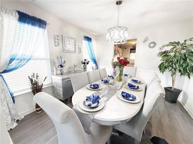 dining area with an inviting chandelier, baseboards, and wood finished floors