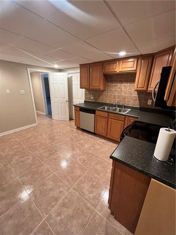 kitchen with light tile patterned floors, backsplash, appliances with stainless steel finishes, sink, and a paneled ceiling