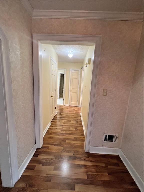 corridor featuring dark wood-type flooring and crown molding