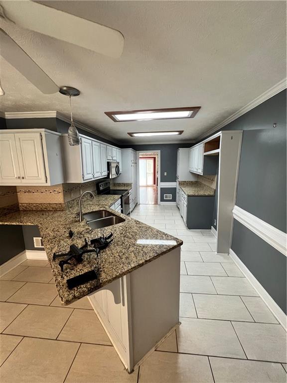 kitchen featuring hanging light fixtures, sink, appliances with stainless steel finishes, and white cabinetry