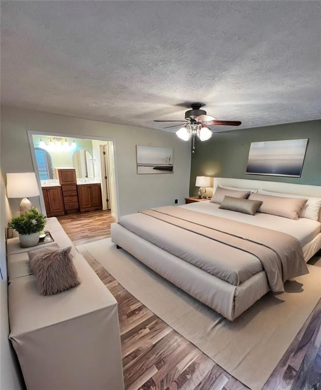 bedroom featuring ceiling fan, hardwood / wood-style flooring, and a textured ceiling