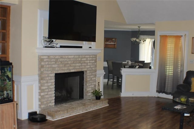 living room featuring wood-type flooring, a chandelier, and a fireplace