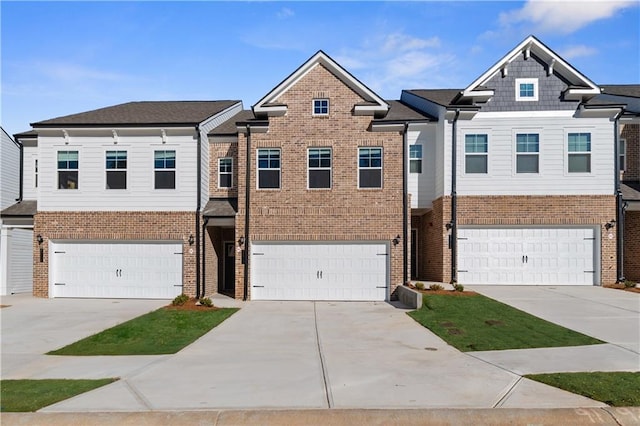 townhome / multi-family property with brick siding, an attached garage, and concrete driveway