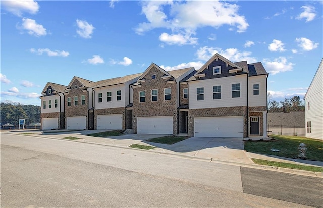 view of front of house featuring a garage, concrete driveway, brick siding, and a residential view