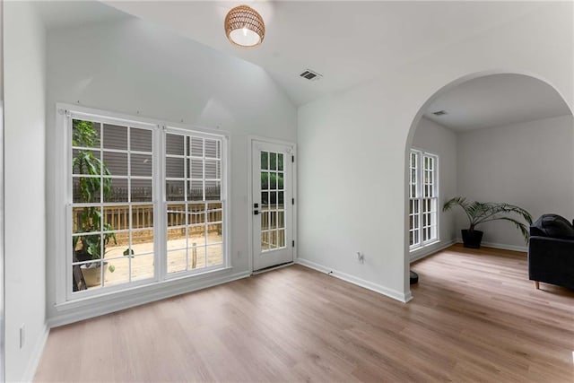 3285 Country Walk Dr, Powder Springs, GA 30127 - empty room with arched walkways, plenty of natural light, wood finished floors, vaulted ceiling, and baseboards