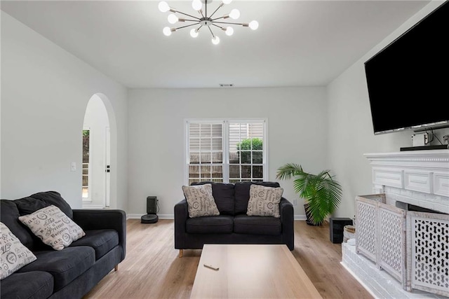 3285 Country Walk Dr, Powder Springs, GA 30127 - living area featuring arched walkways, a chandelier, light wood-type flooring, and a fireplace