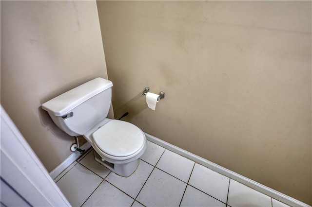 bathroom with tile patterned flooring, toilet, and baseboards