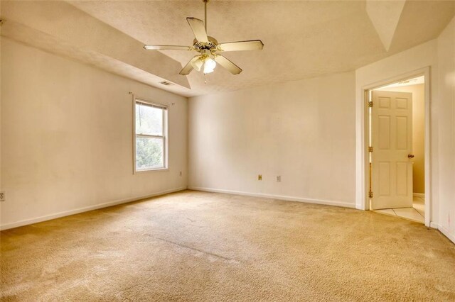 unfurnished room with ceiling fan, baseboards, and light colored carpet