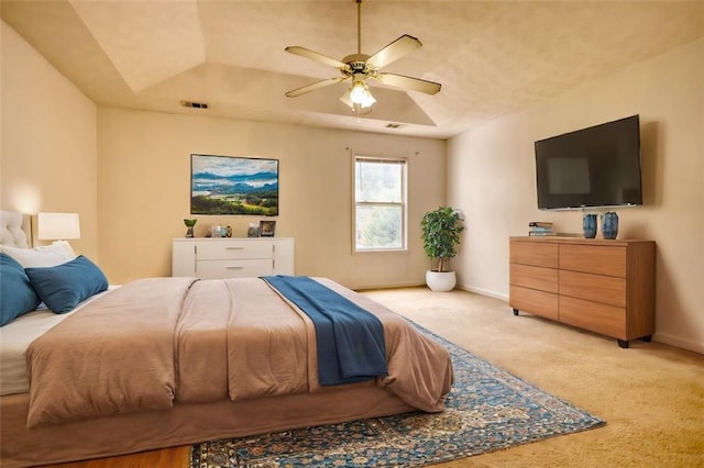 bedroom featuring light carpet, a ceiling fan, visible vents, baseboards, and a raised ceiling