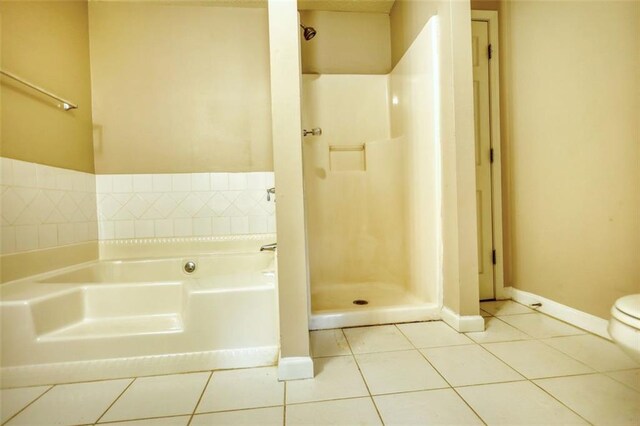bathroom featuring toilet, baseboards, a bath, and tile patterned floors