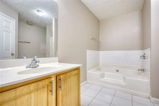 bathroom with a garden tub, visible vents, a textured ceiling, vanity, and tile patterned flooring