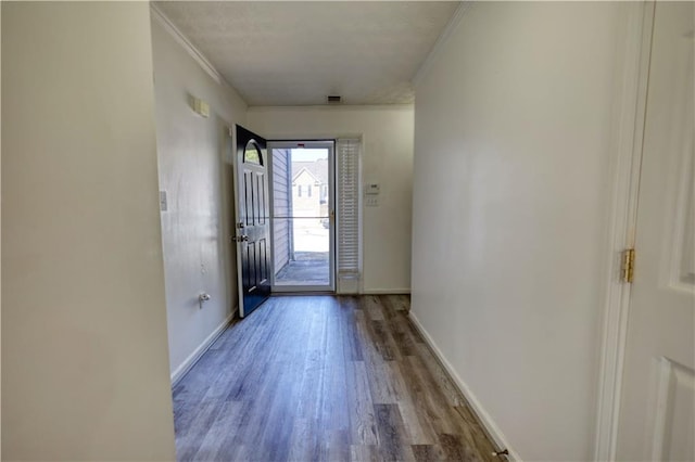 entryway with crown molding, baseboards, and wood finished floors