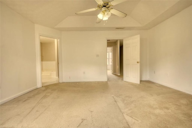 spare room featuring baseboards, a raised ceiling, a ceiling fan, and light colored carpet