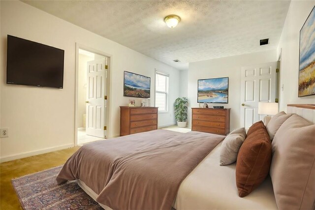 bedroom with light carpet, baseboards, and a textured ceiling