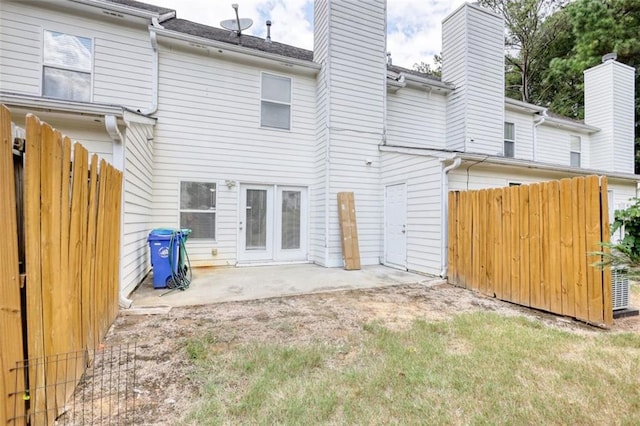 back of property with a patio, a chimney, and fence