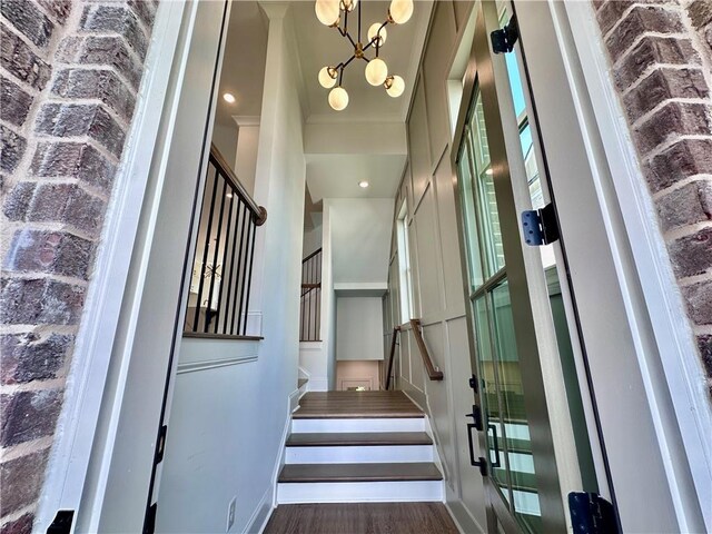 stairway with a notable chandelier and hardwood / wood-style flooring