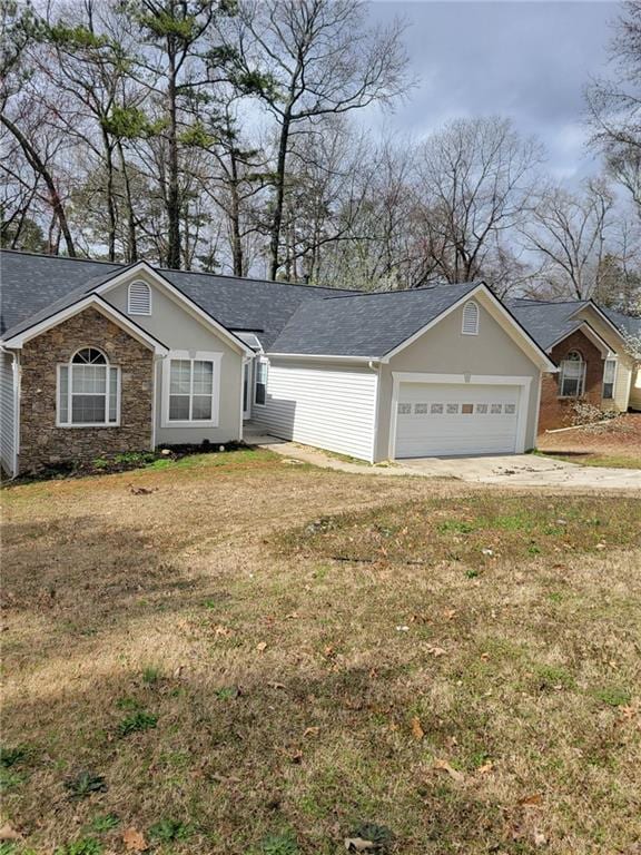 ranch-style home with driveway, stone siding, an attached garage, and a front lawn