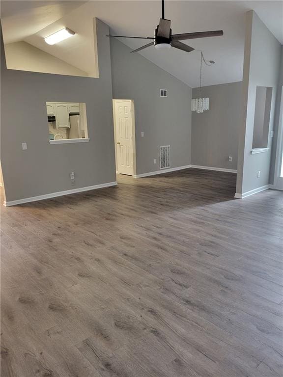 unfurnished living room with baseboards, ceiling fan, visible vents, and dark wood-type flooring