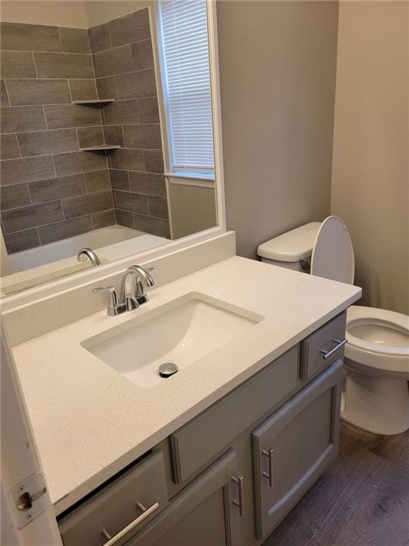 bathroom with a shower, a tub to relax in, toilet, vanity, and wood finished floors