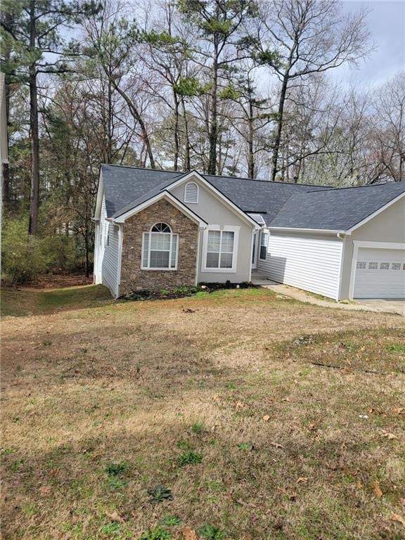 ranch-style house featuring a garage, stone siding, driveway, roof with shingles, and a front yard