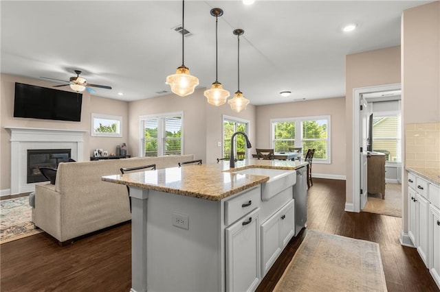 508 Windy Ridge Ct, Canton, GA 30114 - kitchen with dark wood finished floors, ceiling fan, light stone counters, white cabinetry, and a glass covered fireplace
