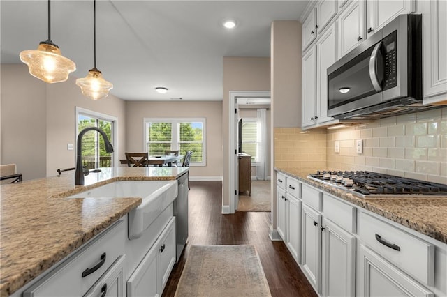 508 Windy Ridge Ct, Canton, GA 30114 - kitchen featuring stainless steel appliances, dark wood-style flooring, decorative backsplash, light stone counters, and decorative light fixtures