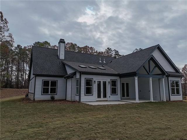 back of property with a yard, french doors, and a patio