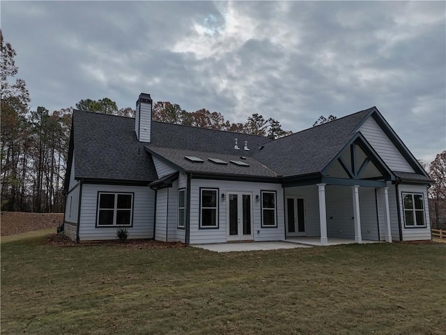 rear view of property with french doors, a patio area, and a yard