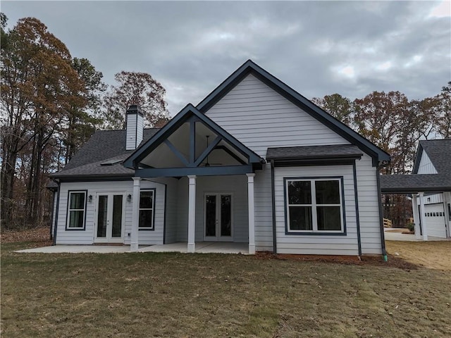 back of house with french doors, a lawn, and a patio