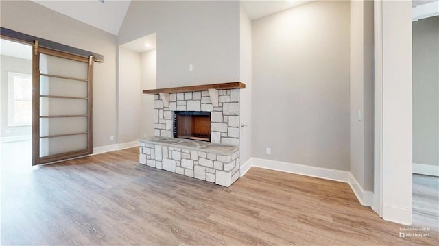 unfurnished living room featuring light wood-type flooring, a fireplace, and vaulted ceiling