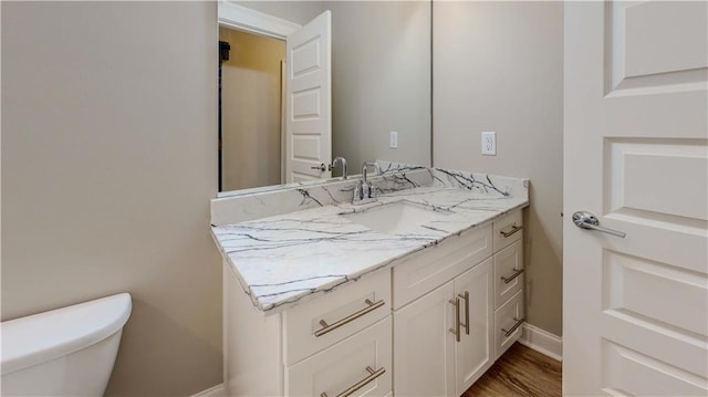 bathroom featuring toilet, hardwood / wood-style flooring, and vanity