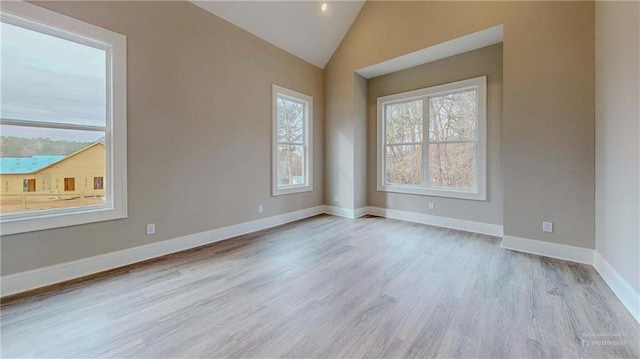 unfurnished room with lofted ceiling and light wood-type flooring