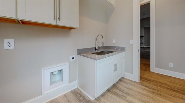 washroom with cabinets, light hardwood / wood-style floors, hookup for an electric dryer, and sink