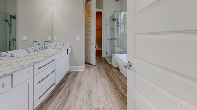 bathroom with separate shower and tub, vanity, and hardwood / wood-style flooring