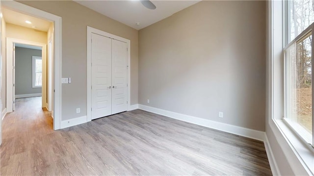 unfurnished bedroom with a closet and light hardwood / wood-style flooring