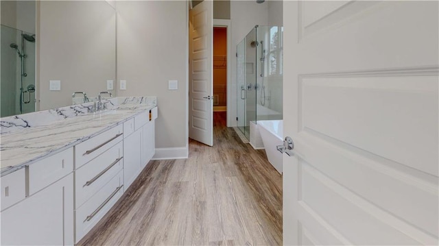 bathroom with hardwood / wood-style flooring, vanity, and independent shower and bath