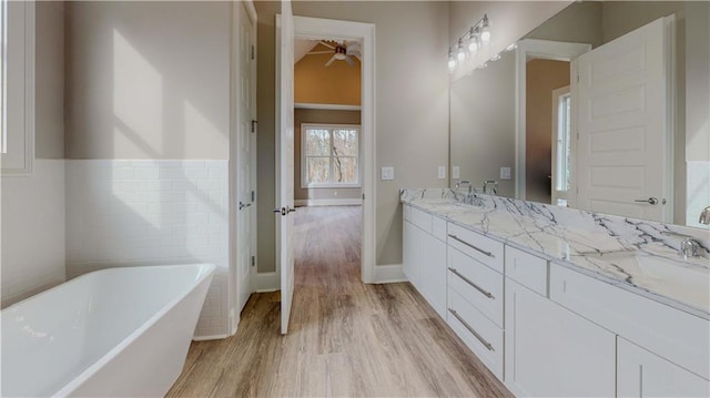 bathroom featuring vanity, wood-type flooring, and a washtub