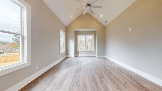 empty room with vaulted ceiling, ceiling fan, and light hardwood / wood-style flooring