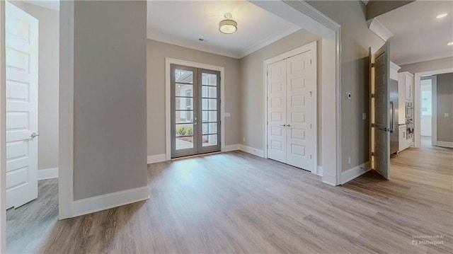 entryway featuring french doors, ornamental molding, and light hardwood / wood-style floors